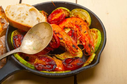 roasted shrimps on cast iron skillet  with zucchini and tomatoes