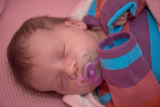 One month newborn baby in bed. Close up portrait of sleeping cute little girl