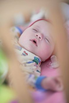 newborn baby girl sleeping in bed at home