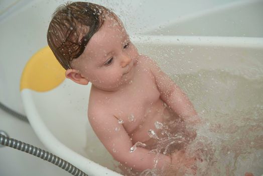 Mother is bathing happy little  baby girl taking a bath