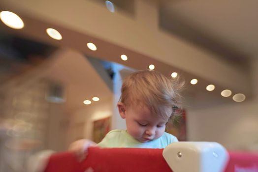 cute  little baby playing with toys in mobile bed making first steps and learnig to stand  and walk