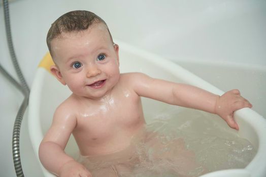 Mother is bathing happy little  baby girl taking a bath