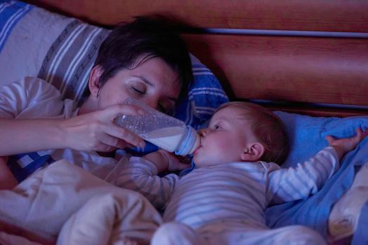 newborn baby is eating milk from bottle