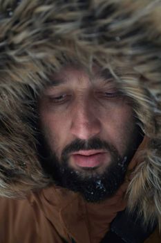 portrait local authentic eskimo  man at winter in stormy weather wearing warm  fur jacket
