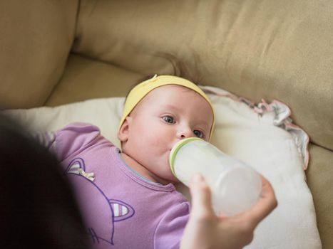 newborn baby is eating milk from bottle