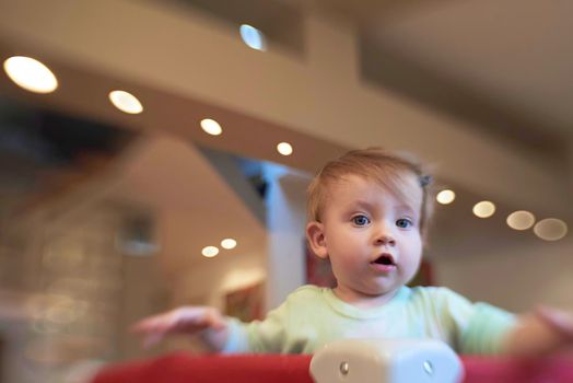 cute  little baby playing with toys in mobile bed making first steps and learnig to stand  and walk