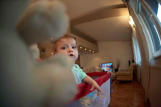 cute  little baby playing with toys in mobile bed making first steps and learnig to stand  and walk