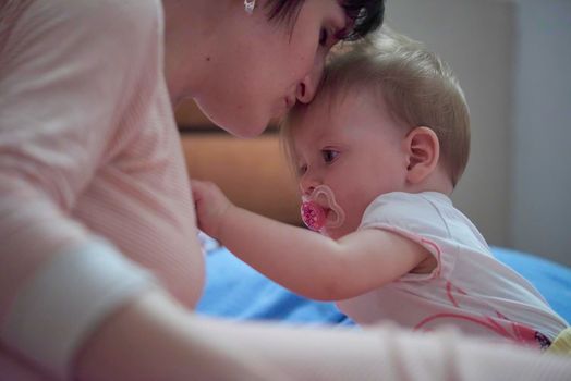 mother is playing with newborn baby at home