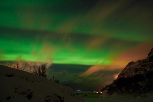 Aurora borealis Green northern lights above mountains on the Lofoten islands, Norway. Night sky with polar lights. Night winter landscape with aurora.