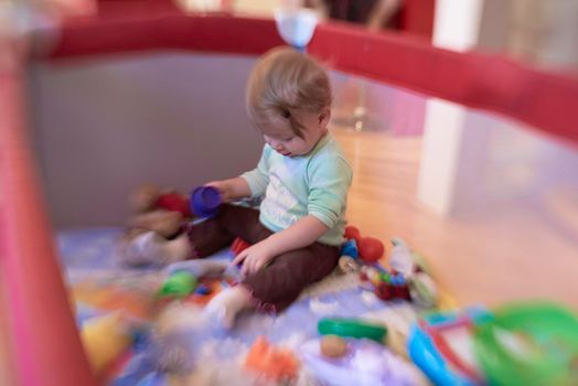 cute  little baby playing with toys in mobile bed making first steps and learnig to stand  and walk