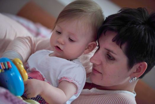 mother is playing with newborn baby at home