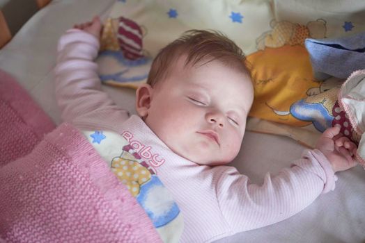 newborn baby girl sleeping in bed at home