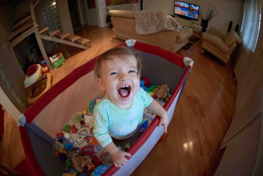 cute  little baby playing with toys in mobile bed making first steps and learnig to stand  and walk
