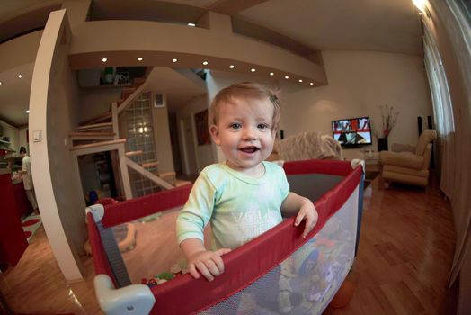 cute  little baby playing with toys in mobile bed making first steps and learnig to stand  and walk