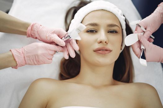 Cosmetologist treats client's skin. Woman with cosmetologist. Lady in a beauty studio.