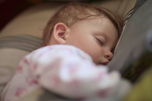 newborn baby girl sleeping in bed at home