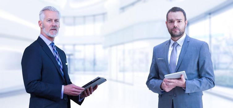 Portrait of two colleague businessmans using tablet in front of the modern IT company