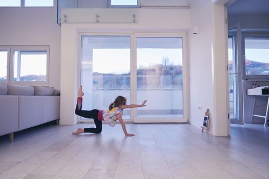 Little girl have online training over  tablet and doing modern ballet dance exercise at home. Online education concept class in modern ballet school. Social distance during quarantine, self-isolation in coronavirus