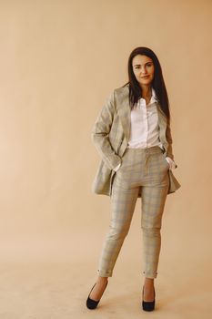 Beautiful girl in a studio. Stylish girl on a brown background. Lady in a jacket.