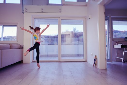 Little girl have online training over  tablet and doing modern ballet dance exercise at home. Online education concept class in modern ballet school. Social distance during quarantine, self-isolation in coronavirus