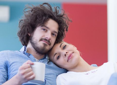 Young couple on the sofa watching television together in their luxury home