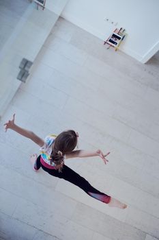 Little girl have online training over  tablet and doing modern ballet dance exercise at home. Online education concept class in modern ballet school. Social distance during quarantine, isolation in coronavirus top view