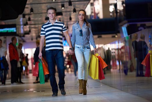 young couple with shipping bags in modern mall