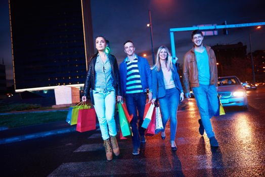 Group Of Friends Enjoying Shopping Trip Together
group of happy young frineds enjoying shopping night and walking on steet on night in with mall in background