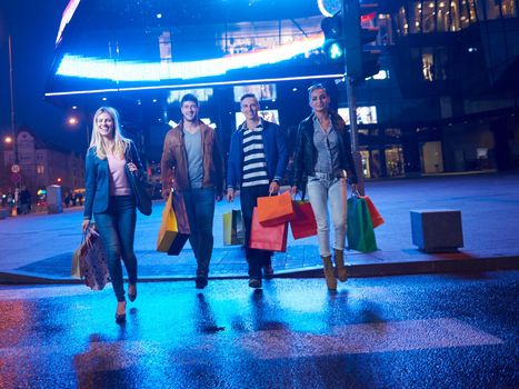 Group Of Friends Enjoying Shopping Trip Together
group of happy young frineds enjoying shopping night and walking on steet on night in with mall in background