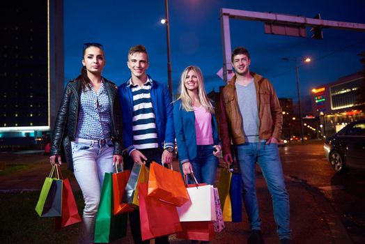 Group Of Friends Enjoying Shopping Trip Together
group of happy young frineds enjoying shopping night and walking on steet on night in with mall in background