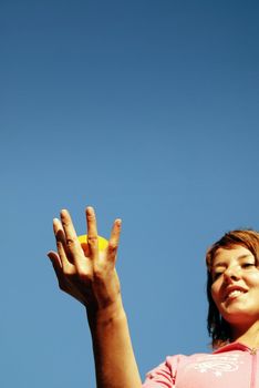 beautiful young woman throwing fresh orange in to air