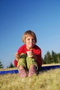 happy llittle girl eating healthy food in nature