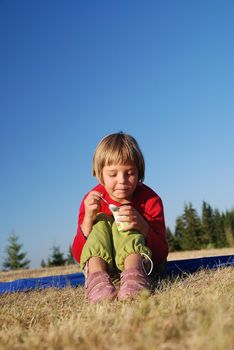 happy llittle girl eating healthy food in nature