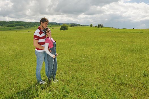 Portrait of romantic young couple in love  smiling together outdoor in nature with blue sky in background