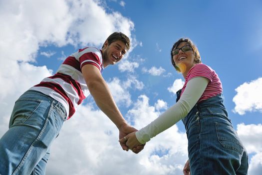 Portrait of romantic young couple in love  smiling together outdoor in nature with blue sky in background