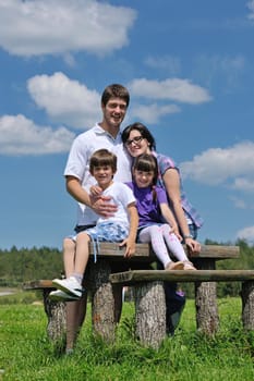 happy young family with their kids have fun and relax outdoors in nature with blue sky in background