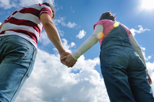 Portrait of romantic young couple in love  smiling together outdoor in nature with blue sky in background