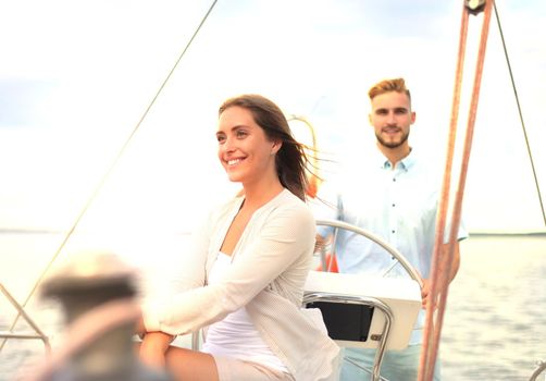 Attractive couple on a yacht enjoy bright sunny day on vacation.