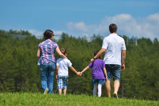 happy young family with their kids have fun and relax outdoors in nature with blue sky in background