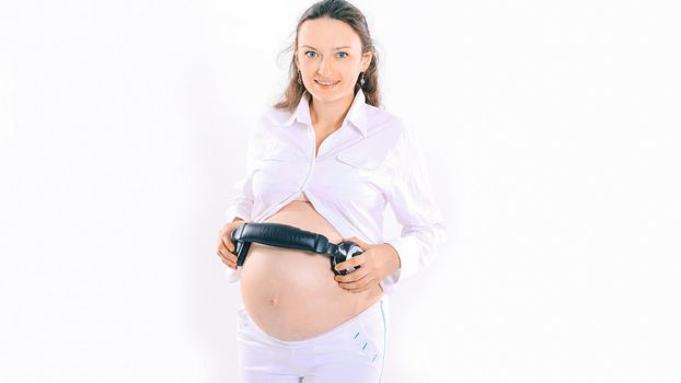 happy pregnant woman puts headphones on her tummy.isolated on white background
