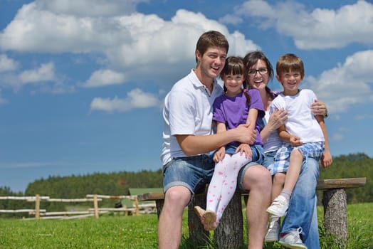 happy young family with their kids have fun and relax outdoors in nature with blue sky in background