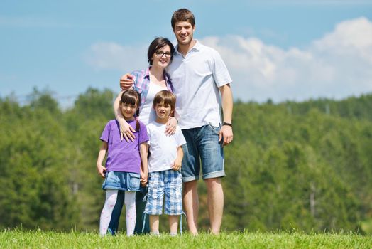 happy young family with their kids have fun and relax outdoors in nature with blue sky in background