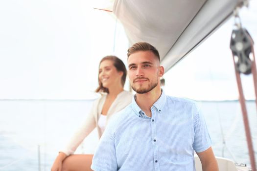 Attractive couple on a yacht enjoy bright sunny day on vacation.