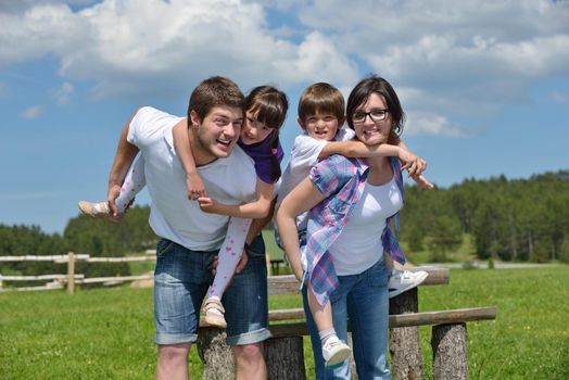 happy young family with their kids have fun and relax outdoors in nature with blue sky in background