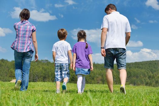 happy young family with their kids have fun and relax outdoors in nature with blue sky in background