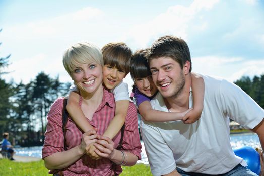 happy young family with their kids have fun and relax outdoors in nature with blue sky in background