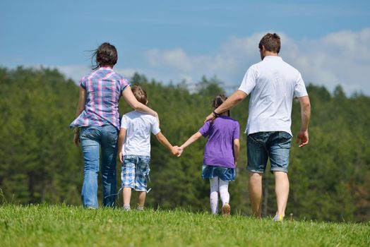 happy young family with their kids have fun and relax outdoors in nature with blue sky in background