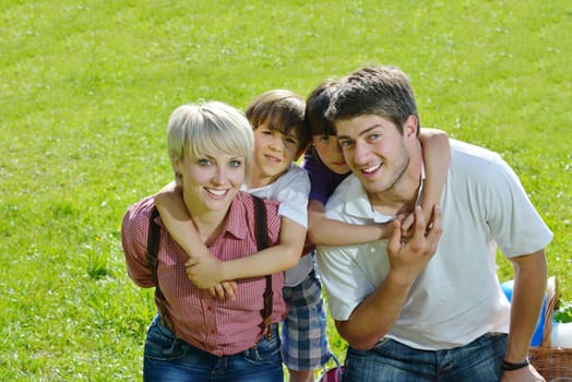 happy young family with their kids have fun and relax outdoors in nature with blue sky in background