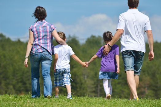 happy young family with their kids have fun and relax outdoors in nature with blue sky in background