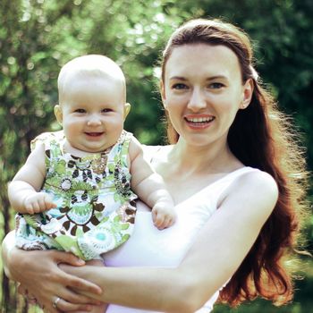 Beautiful Mother And Baby outdoors. Nature. Beauty Mum and her Child playing in Park together